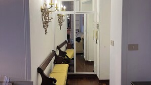 Un corridoio con una panca in legno, uno specchio e un lampadario.