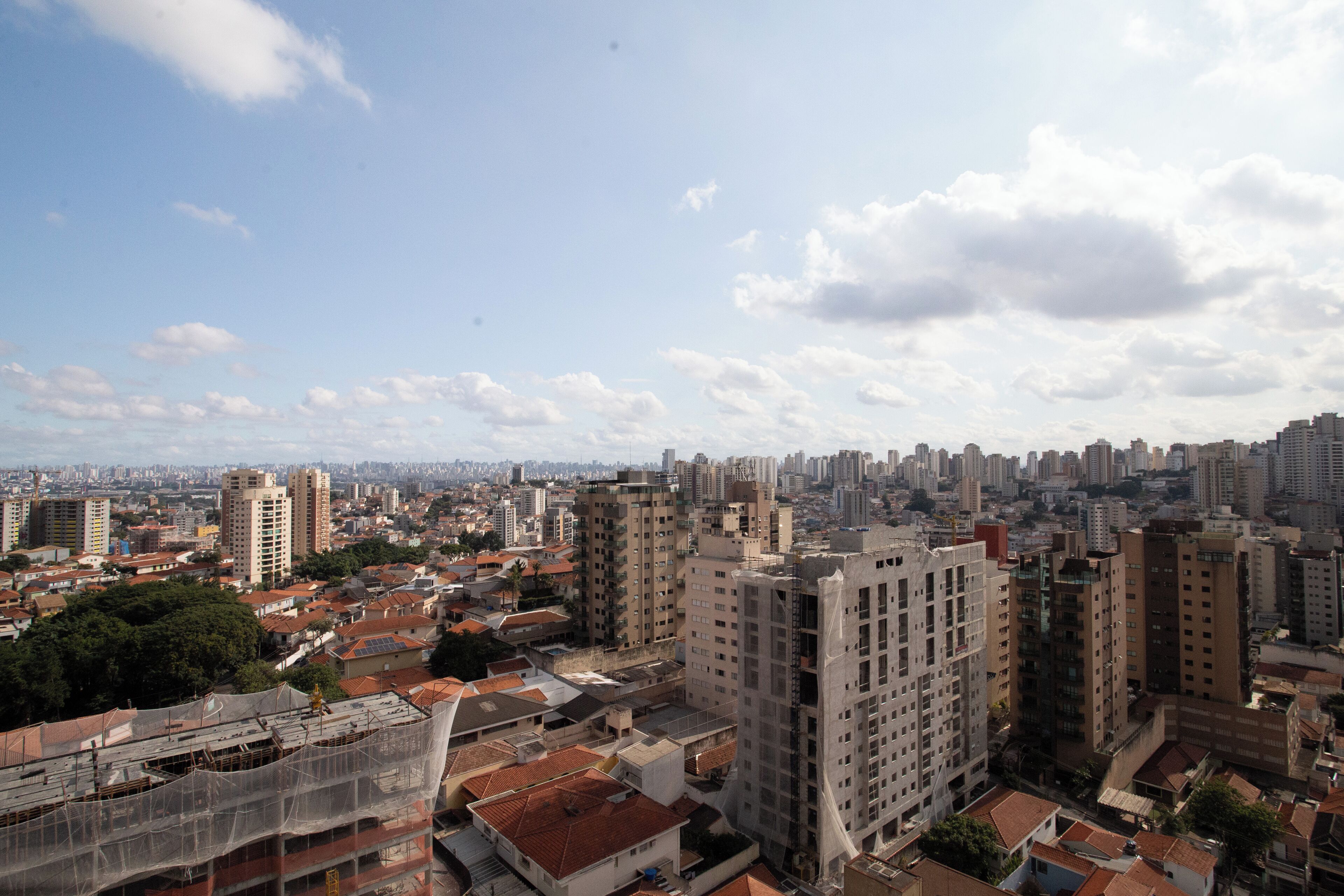 A cityscape with high-rise buildings, a mix of residential and commercial structures, and a clear sky.