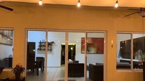 A spacious living area with a sliding glass door leading to a dining area and a kitchen. - Cuernavaca In Sumiya San José: dream garden. (Jiutepec)