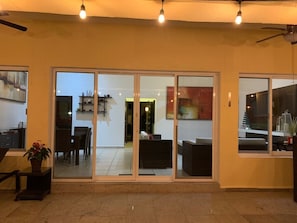 A spacious living area with a sliding glass door leading to a dining area and a kitchen. - Cuernavaca In Sumiya San José: dream garden. (Jiutepec)