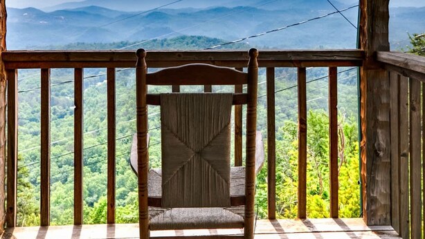 A wooden deck with a wooden chair facing a scenic mountain view. - Super View Smoky Mtn Log Cabin Pool Table Hot Tub (Sevierville)