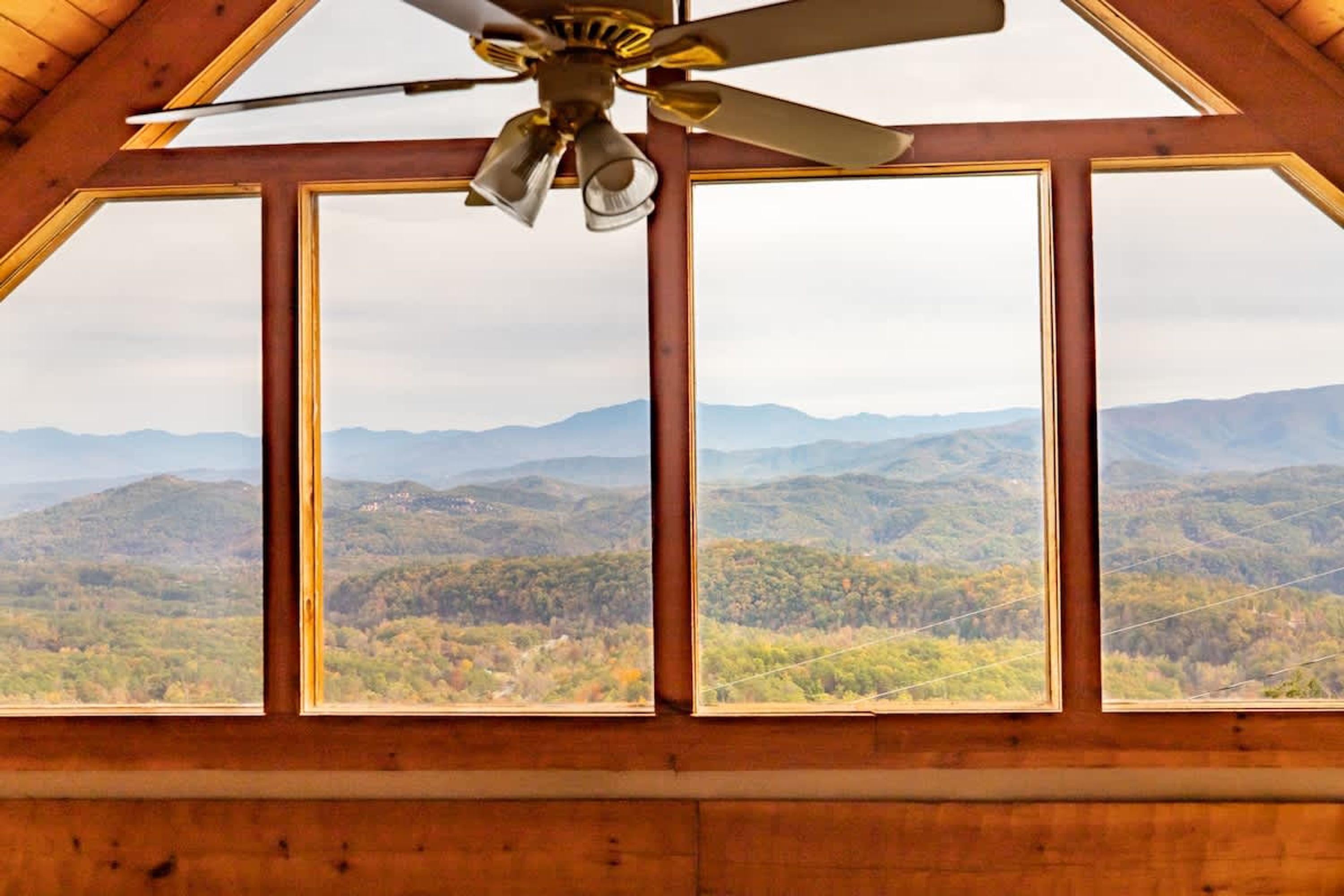 A room with a large window offering a view of a mountainous landscape.