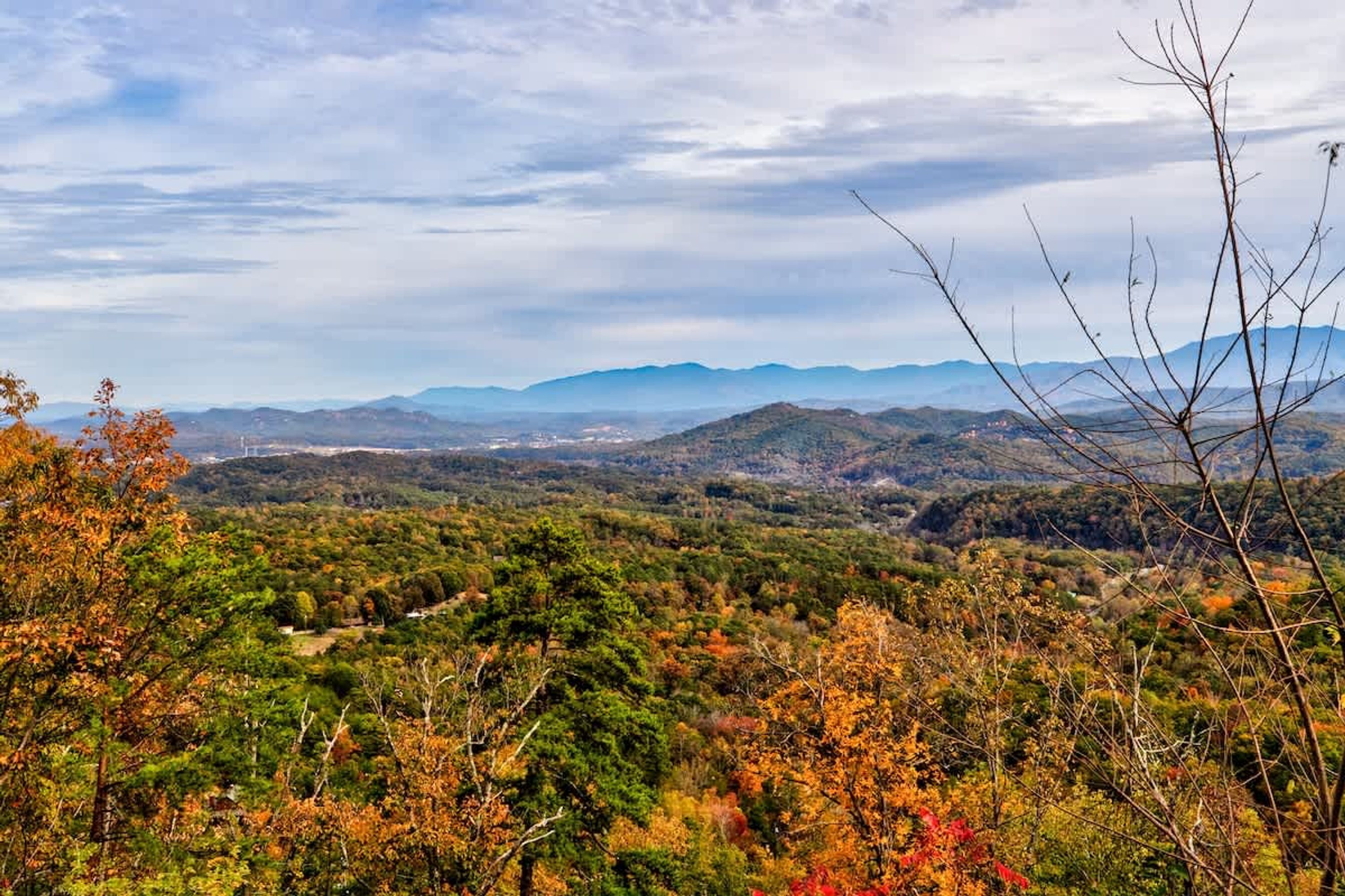 Vista panorâmica de uma paisagem montanhosa com folhagem outonal.