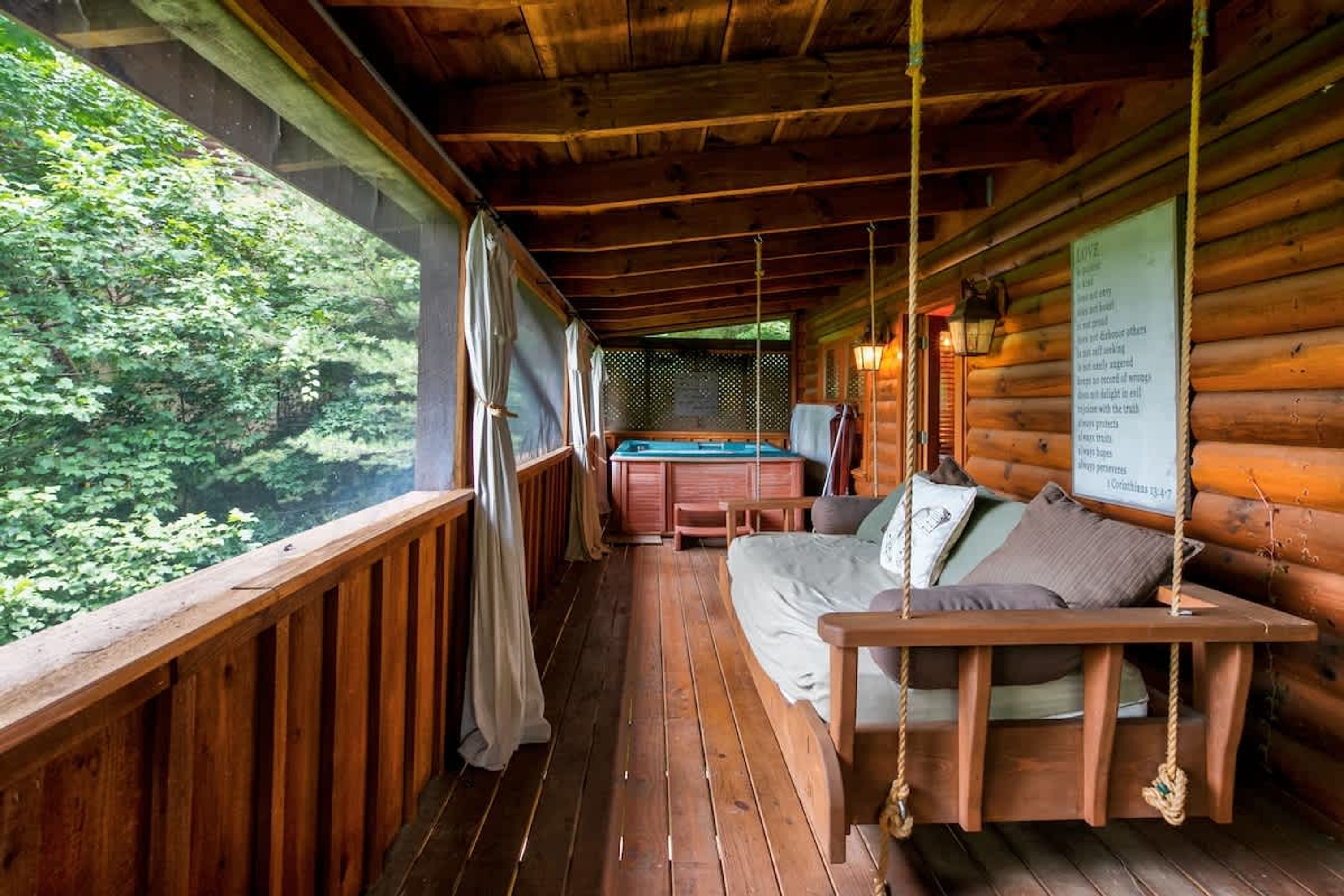 A cozy cabin with a wooden deck, a bed with a swing, a pool table, and a sign with a list of items.