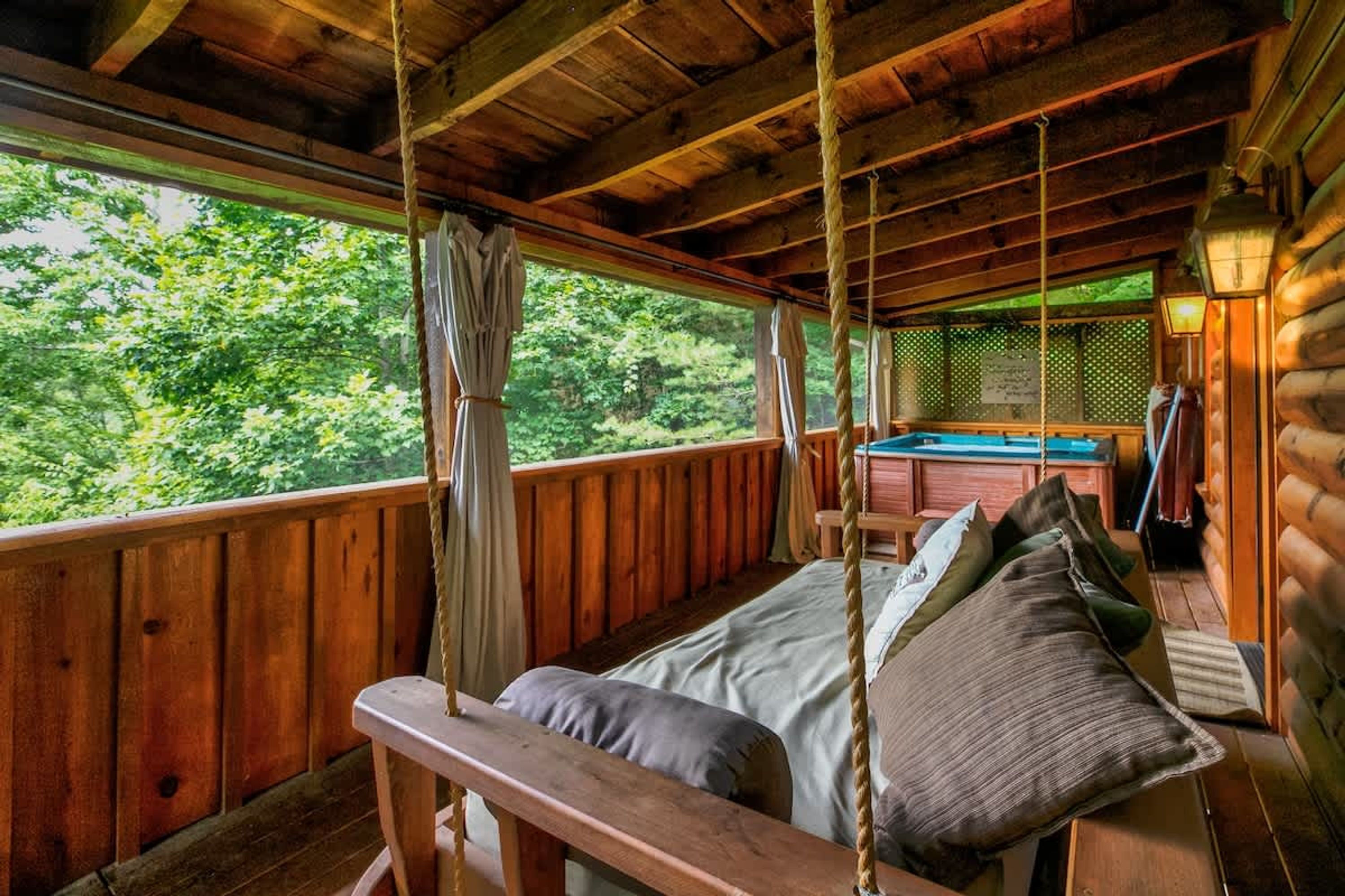 Eine Holzhütte mit Bett, Schaukel und Billardtisch.