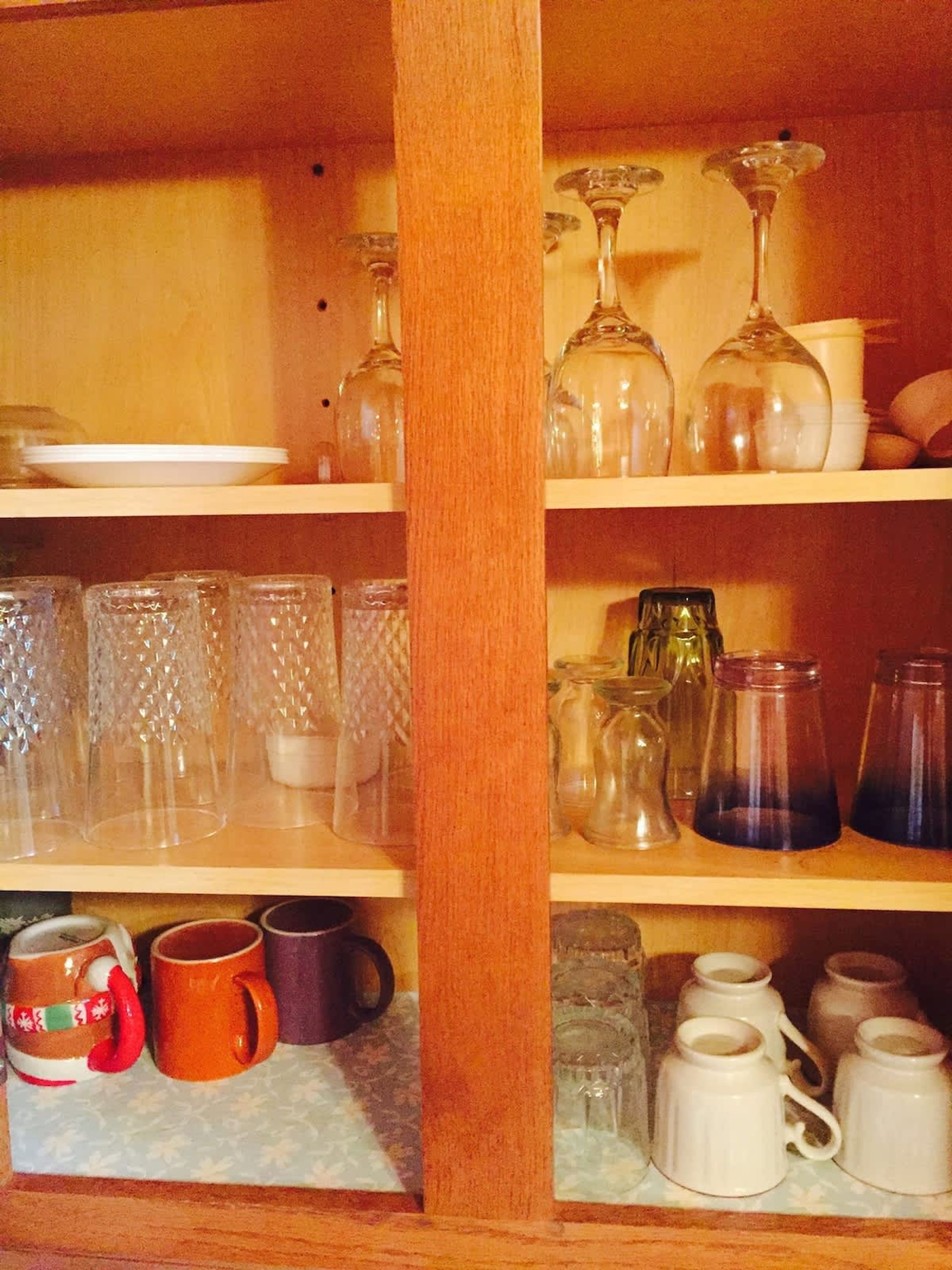 Una estantería de madera con varios vasos y tazas.