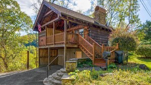 Eine rustikale Holzhütte mit Veranda und einer Treppe, die zum Eingang führt.