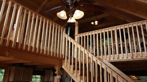A wooden staircase with a railing, a ceiling fan, and a light fixture. - View Private Hot Tub Pool Table Fireplace Relax (Sevierville)