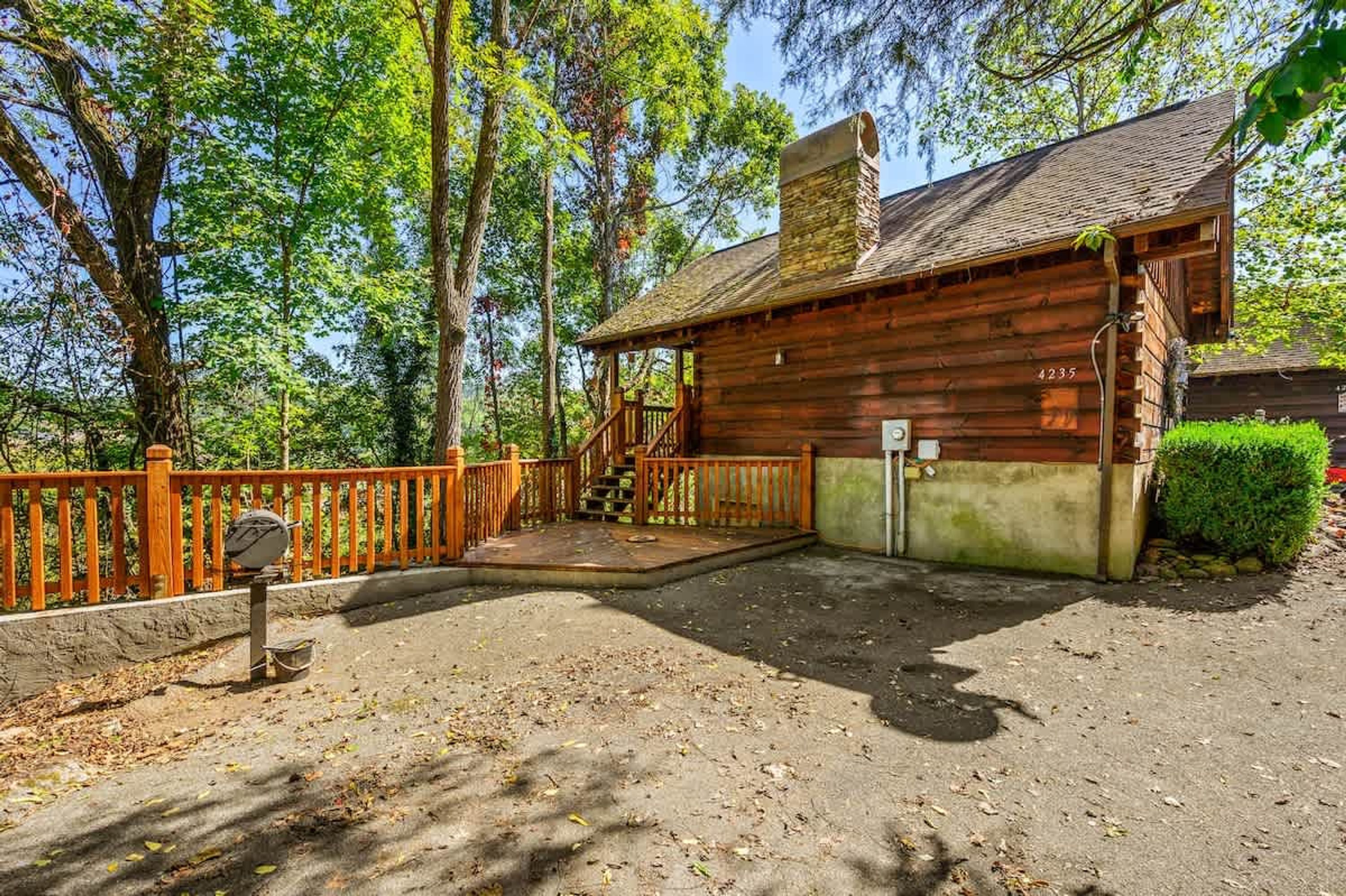 A rustic cabin with a wooden exterior, a chimney, and a porch with a railing.