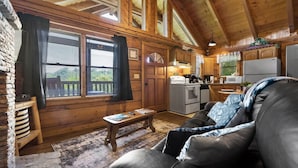 A cozy cabin interior with a wooden interior, a dining area, and a kitchen.