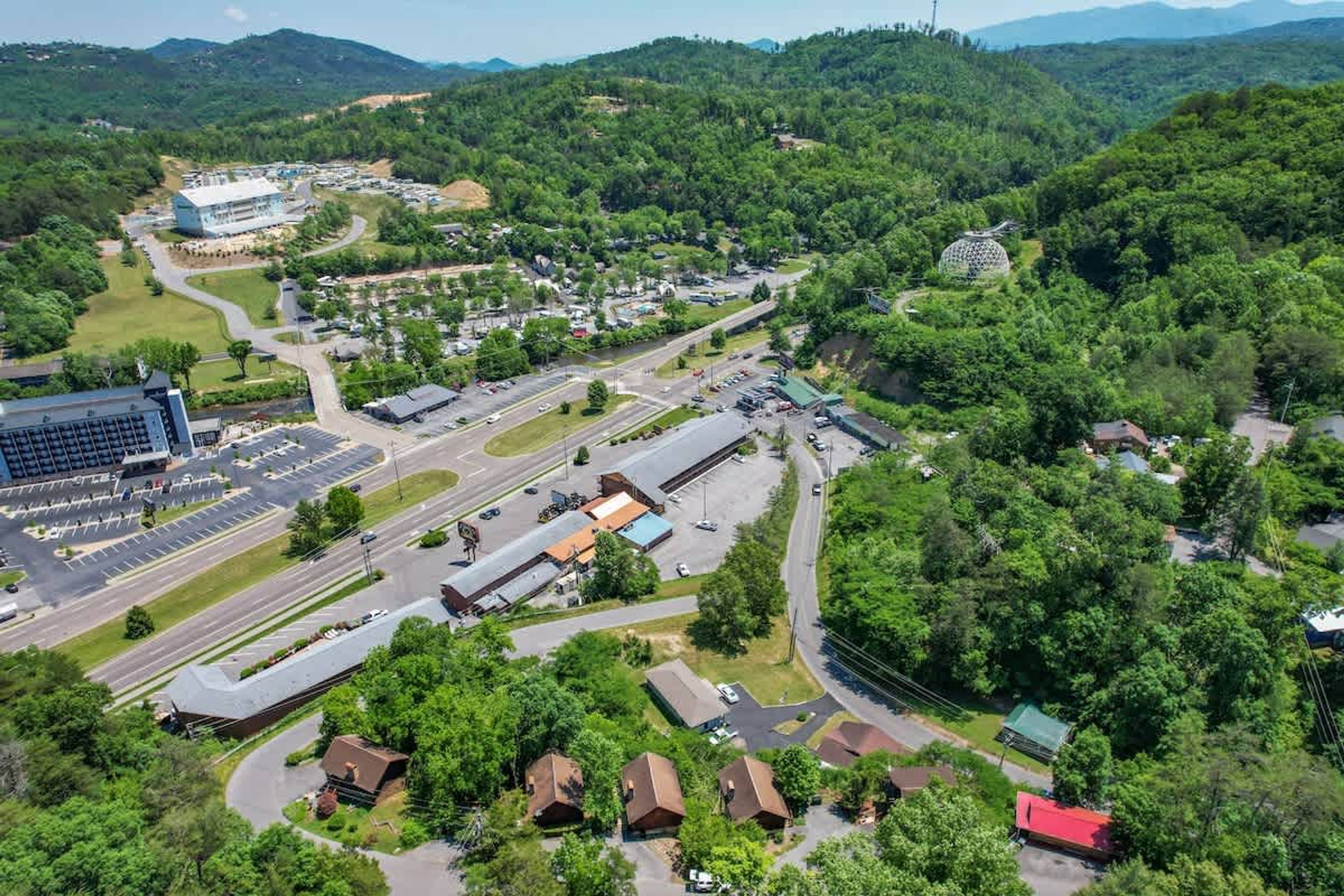 An aerial view of a town with a mix of residential and commercial buildings, roads, and green areas.