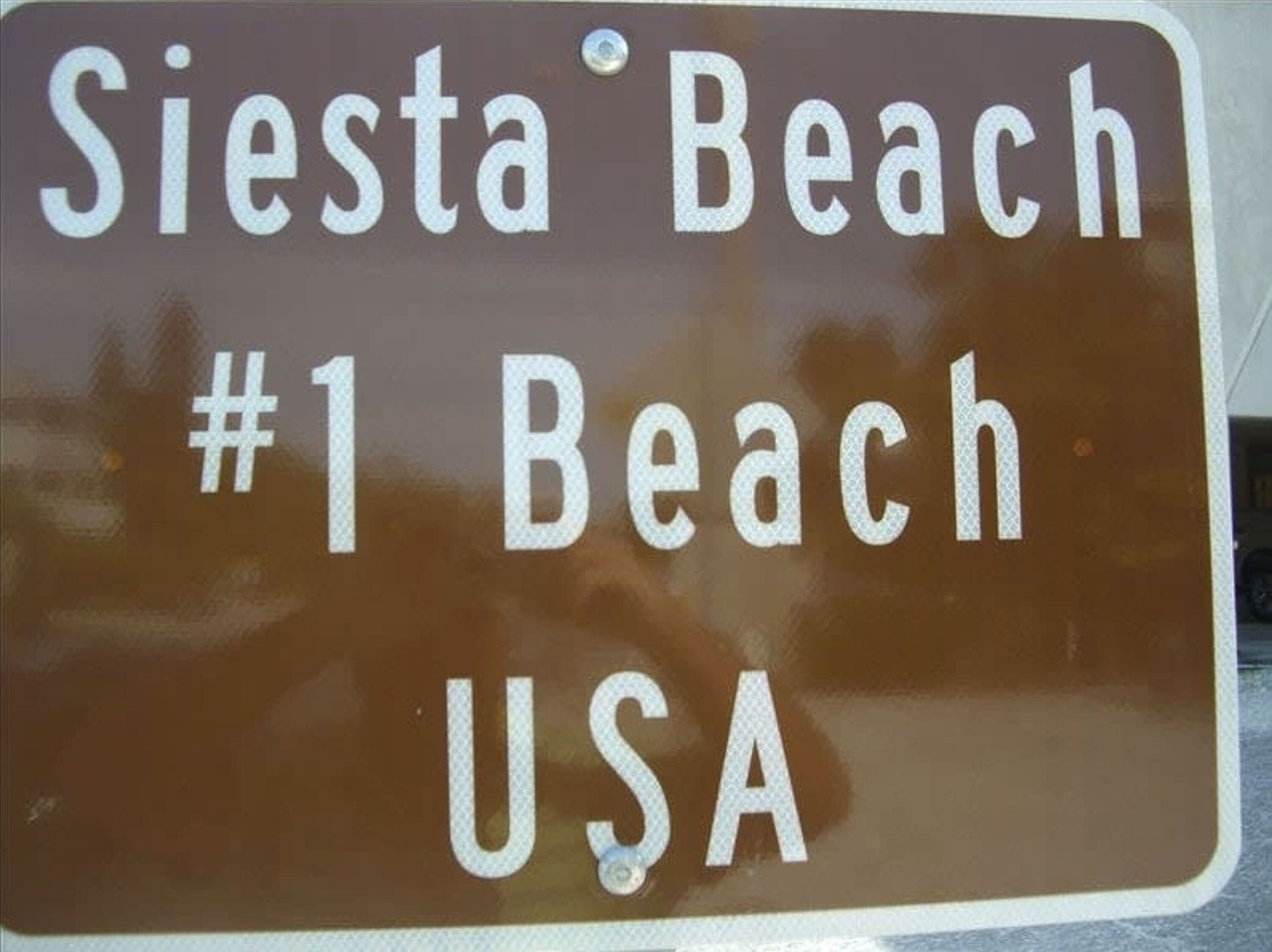 A sign that reads "Siesta Beach #1 Beach USA".
