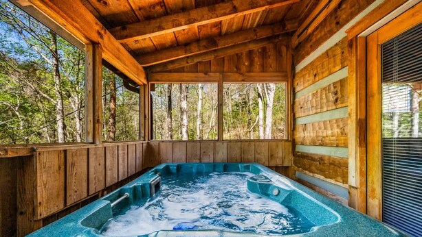 Una cabaña de madera con un jacuzzi.