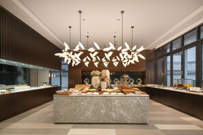 A modern hotel lobby with a marble reception desk, a large window, and a decorative ceiling light fixture. - Hilton Garden Inn Dali Erhai Park (Dali)
