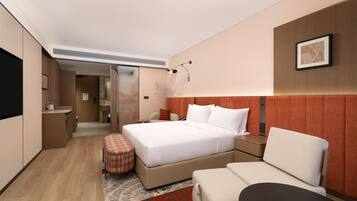 Una habitación de hotel moderna con una cama grande, un sofá, una mesita y un televisor.