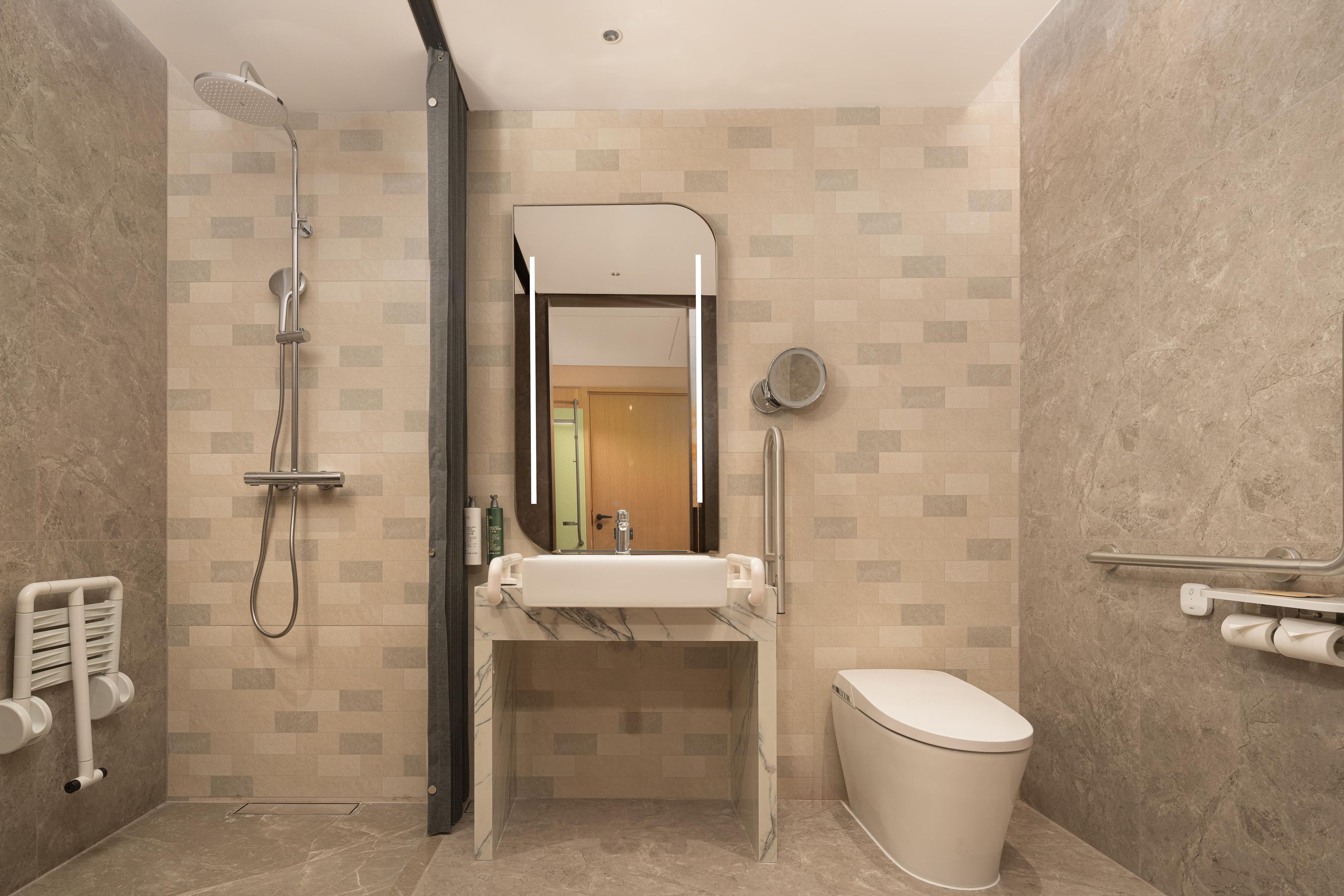 Un baño moderno con ducha, lavamanos, inodoro y espejo.