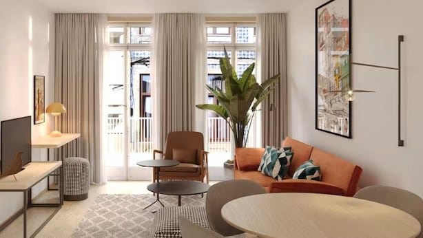 A modern living room with a sofa, two armchairs, a coffee table, a TV, and a large plant. - The 6th Bridge Suites Porto, Tapestry Collection by Hilton (Porto)