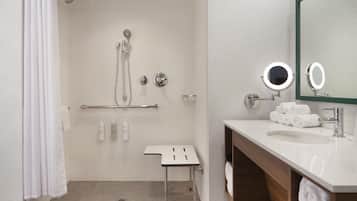 A modern bathroom with a shower, a vanity with a mirror, and a towel rack.