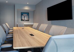 A conference room with a long table, six chairs, a mounted television, and a framed picture on the wall. - Home2 Suites by Hilton Texarkana (Texarkana)