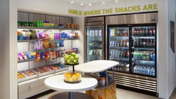 A snack display area with various packaged snacks and a bowl of apples.