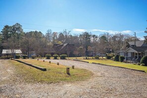 A residential area with a gravel driveway, houses, and a large tree. - Lakescape on Lake Murray w/Private Dock- Leesville (Leesville)