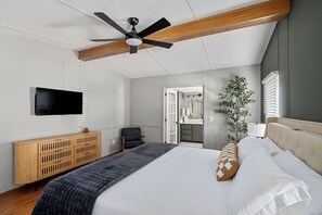 A bedroom with a bed, a ceiling fan, a TV, a wooden console, and a plant. - Lakescape on Lake Murray w/Private Dock- Leesville (Leesville)