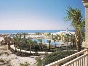 Ein Resort mit Pool, Palmen und Blick auf den Strand.