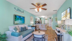 A living room with a sofa, coffee table, and a ceiling fan. - Grand Caribbean 111- Ground Level by Pool (Orange Beach)