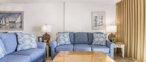 A living room with two sofas, a coffee table, and decorative pillows.
