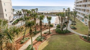 A hotel with a pool, palm trees, and a view of the beach. - Seaside Beach 5417- Two Bedrooms Waterfront Condo With Pool Sauna Amazing Ocean View Balcony (Orange Beach)