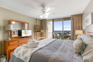 A bedroom with a bed, a television, a ceiling fan, a large window with a view, and a balcony. - Seaside Beach 5417- Two Bedrooms Waterfront Condo With Pool Sauna Amazing Ocean View Balcony (Orange Beach)