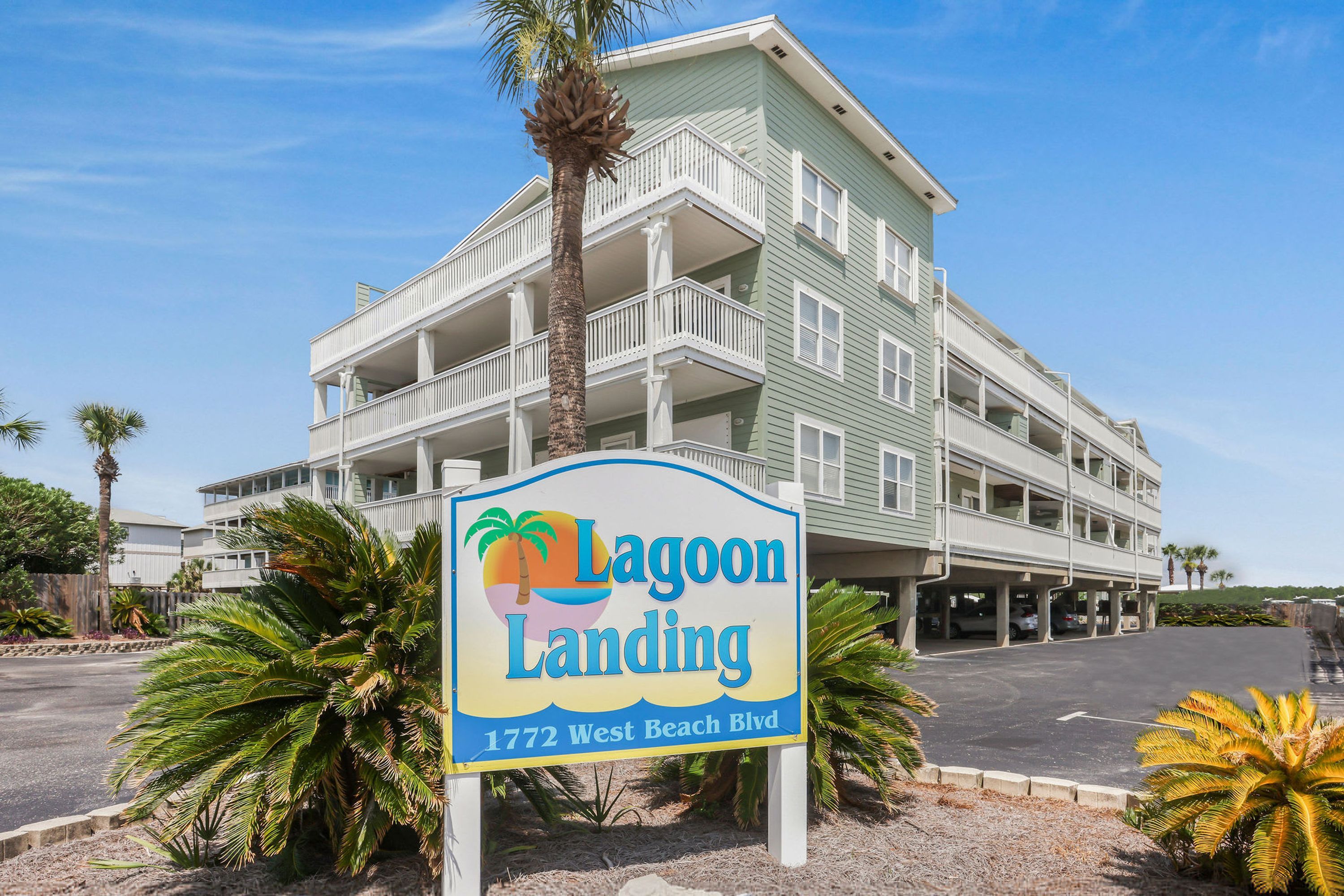 Un edificio de varios pisos con un letrero que dice 'Lagoon Landing 1772 West Beach Blvd.'