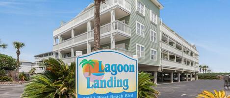 Un edificio de varios pisos con un letrero que dice 'Lagoon Landing 1772 West Beach Blvd.'