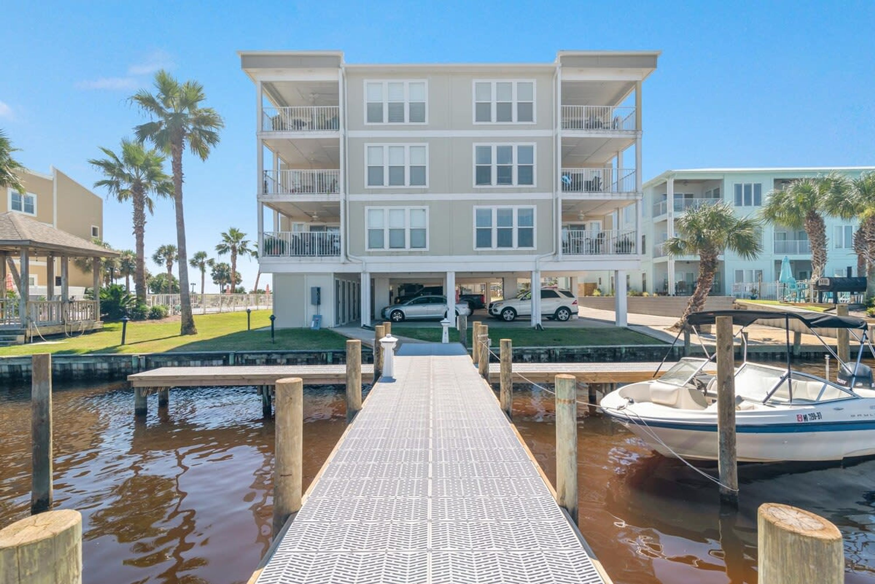 A multi-story hotel with balconies, a dock, and a boat.