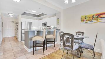 A modern kitchen with white cabinets, stainless steel appliances, and a central island with bar stools.