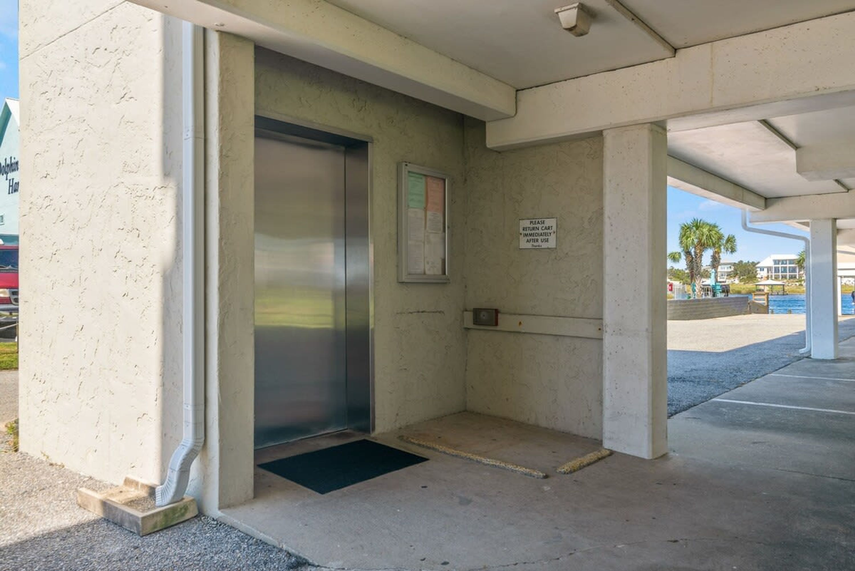 En elevator i en bygning med et skilt, der beder om at returnere indkøbsvognen med det samme.