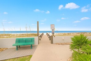 A wooden boardwalk leading to a beach with a green bench and a sign indicating beach access. - Silver Beach 302 Beachfront 3rd Floor Pool (Orange Beach)