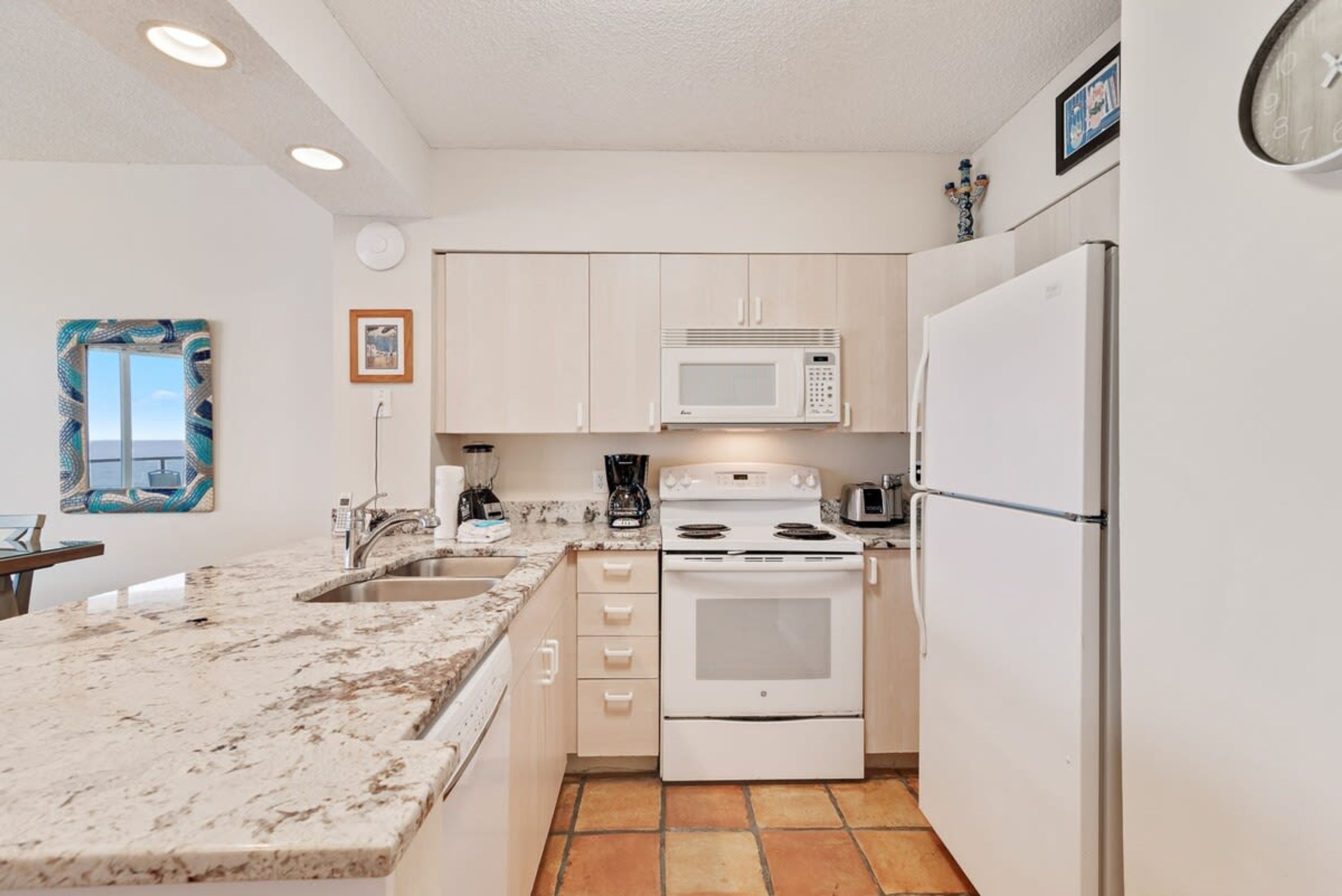 A compact kitchen with white cabinets, a built-in microwave, a stove, and a refrigerator.