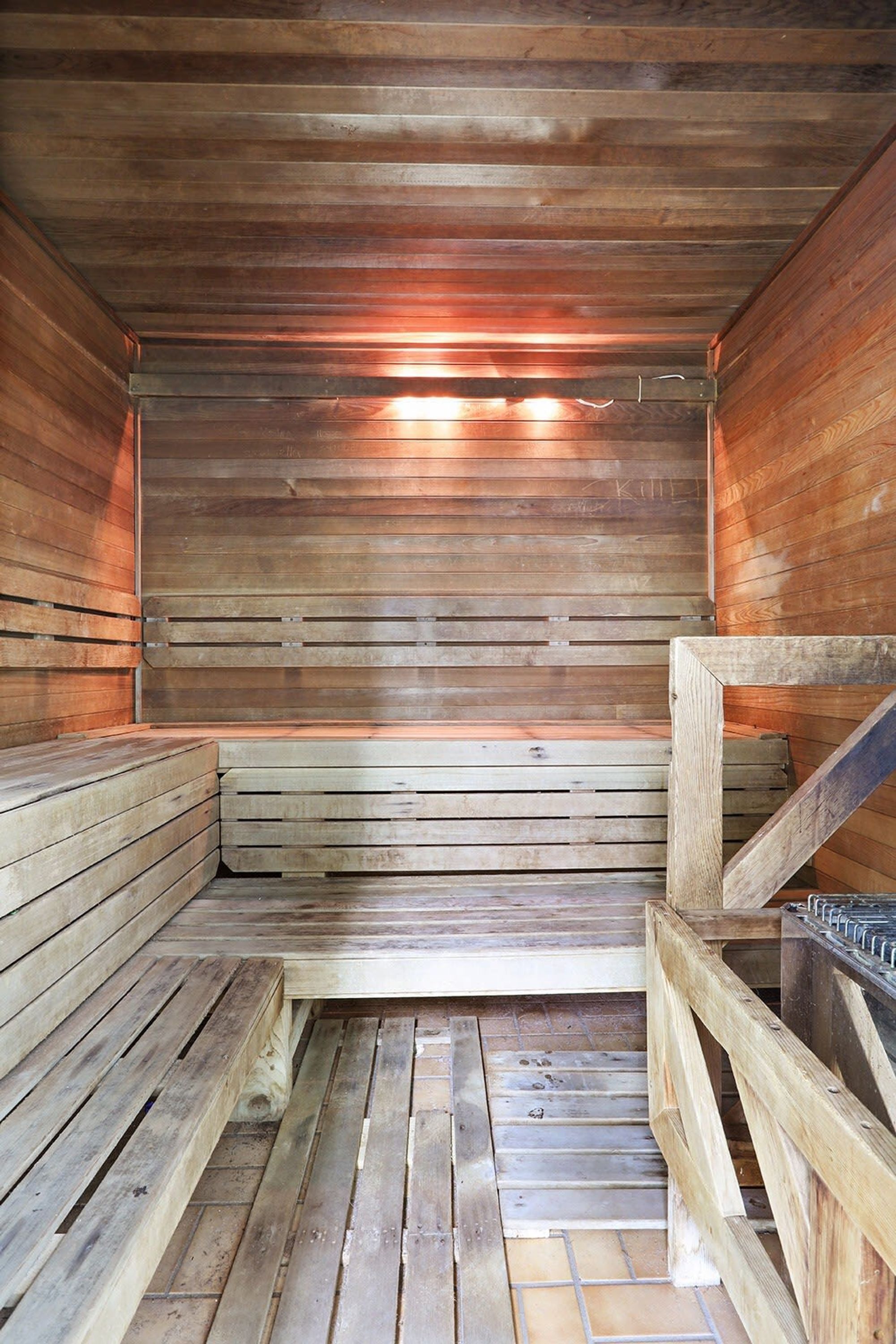 A sauna with wooden benches and a tiled floor.
