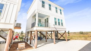 A two-story beachfront house with a balcony, elevated on stilts, and a covered porch. - La Casita new Beach Cottage Easy Beach Access (Gulf Shores)
