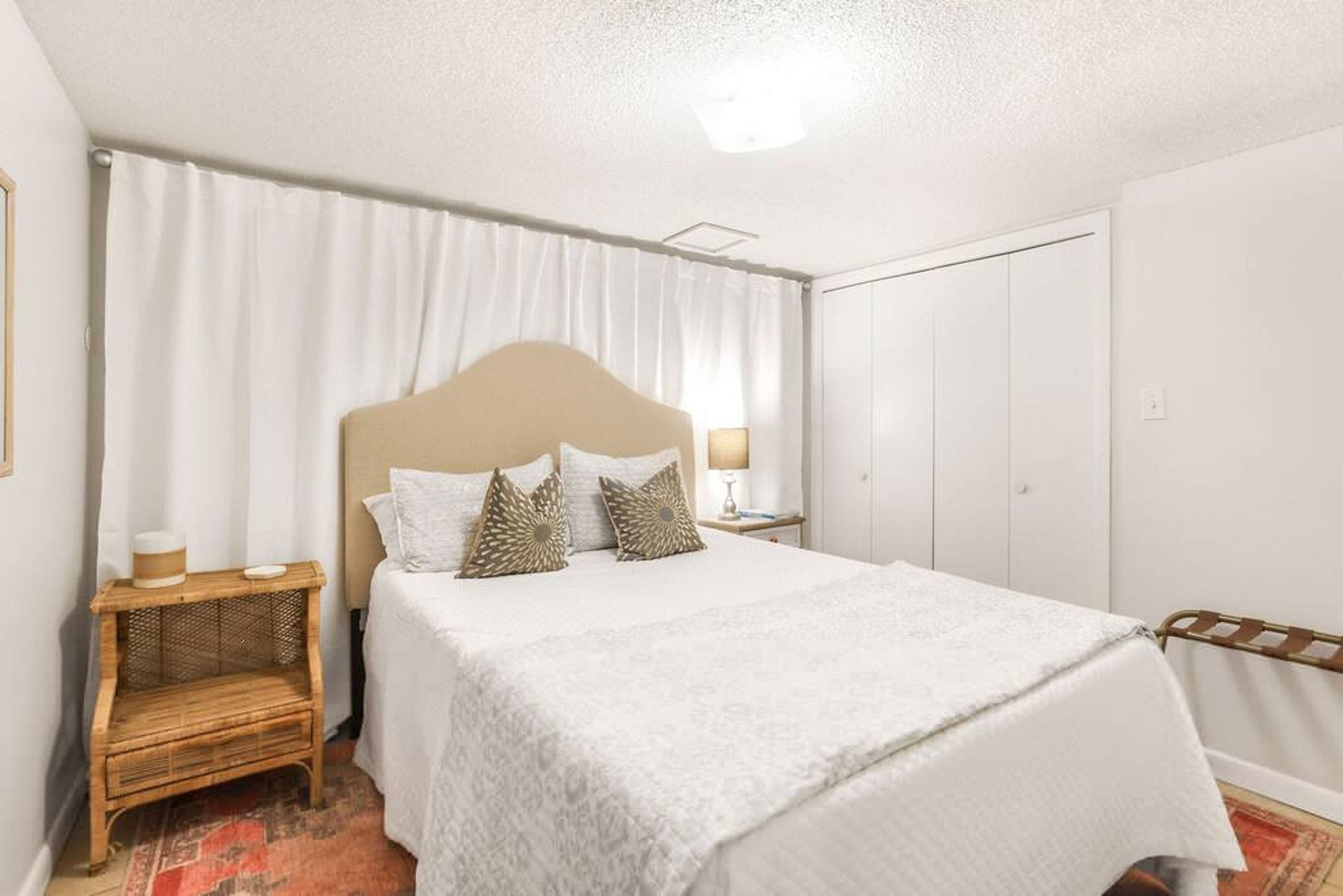 A neatly arranged bedroom with a bed, a nightstand, and a wardrobe.