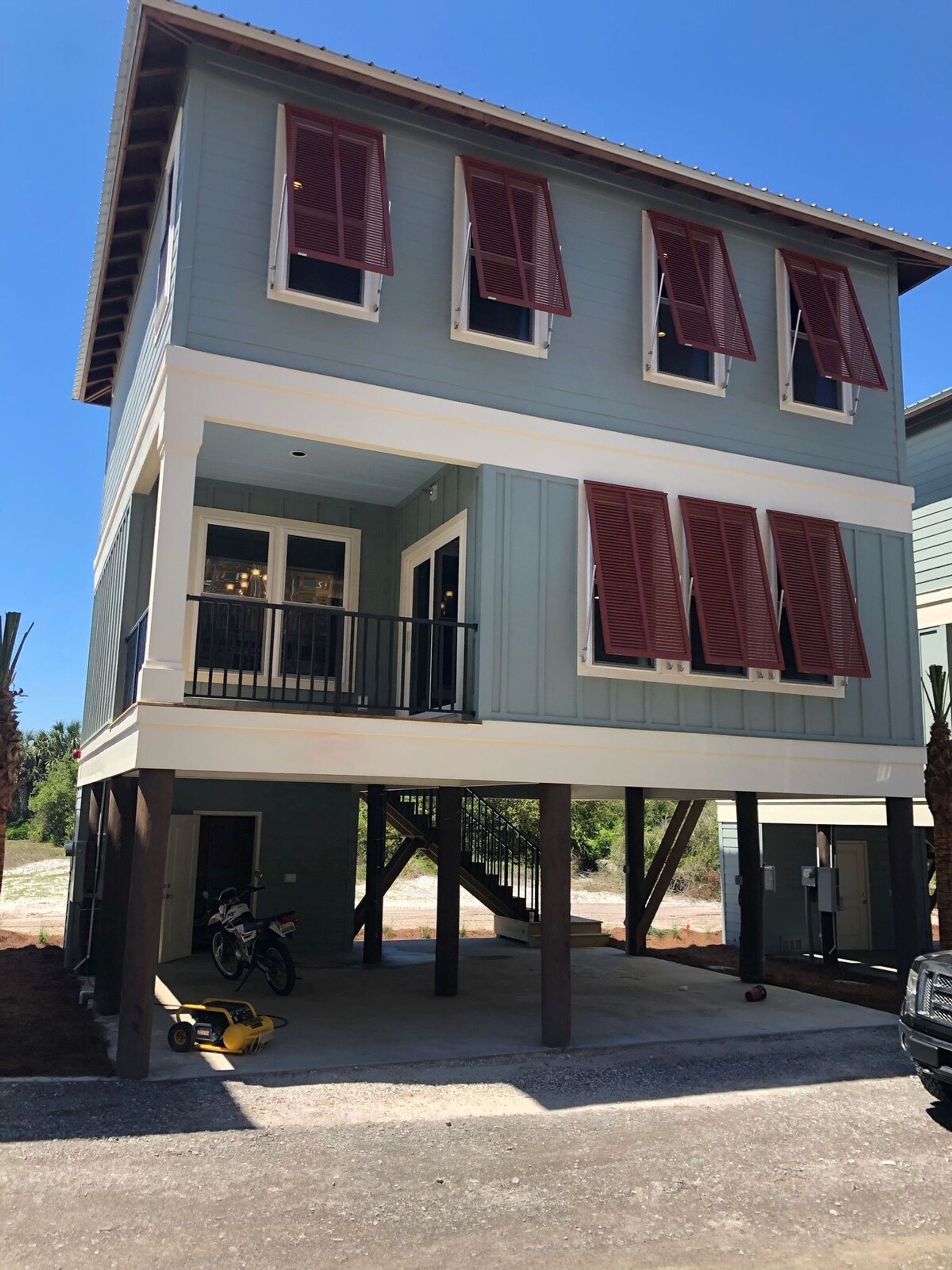 Ein zweistöckiges Haus mit Balkon, Garage und einem Motorrad.