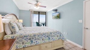 Ein Schlafzimmer mit Bett, Deckenventilator, Fenster und Tür.