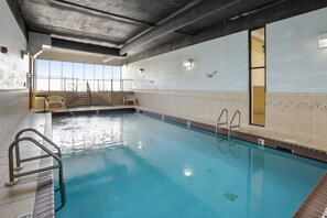 An indoor swimming pool with clear water, metal railings, and a view of the sky through large windows. - Phoenix II Orange Beach Beach Views Pools Fun (Orange Beach)