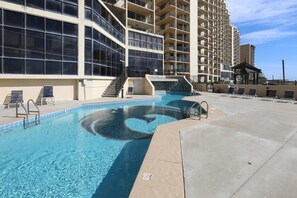 A swimming pool with steps leading into it, surrounded by a concrete deck and lounge chairs. - Phoenix II Orange Beach Beach Views Pools Fun (Orange Beach)