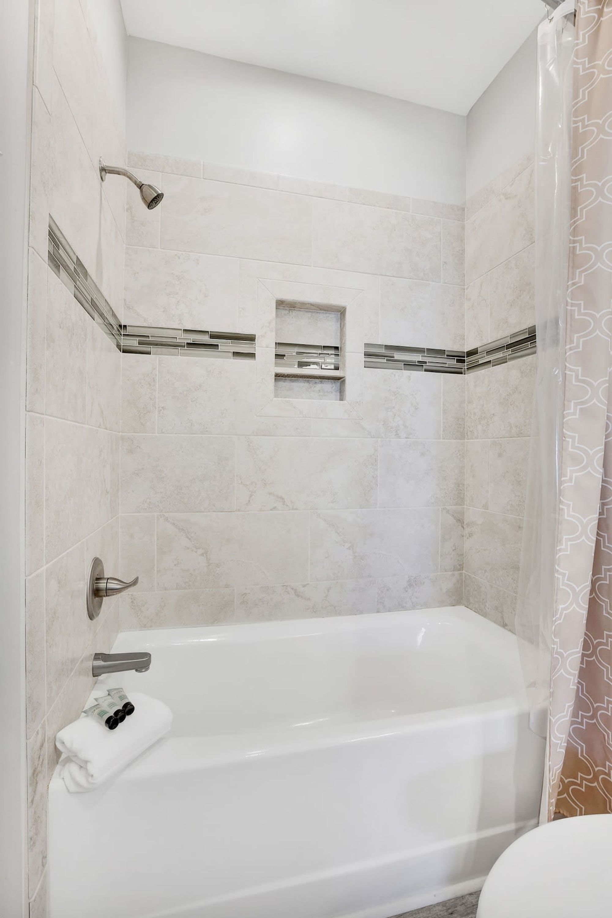 A modern bathroom with a freestanding bathtub, a showerhead, and a towel rack.