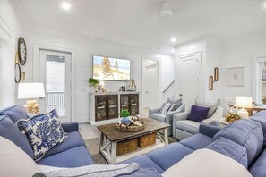 A living room with a sofa set, a coffee table, and a cabinet with decorative items. - Sweet Mama s 4 Bedrooms 4 Baths Cottage Beach Access Pool Sleeps 12 (Gulf Shores)