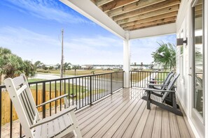 A wooden deck with a railing, a bench, and a view of a residential area. - Sweet Mama s 4 Bedrooms 4 Baths Cottage Beach Access Pool Sleeps 12 (Gulf Shores)