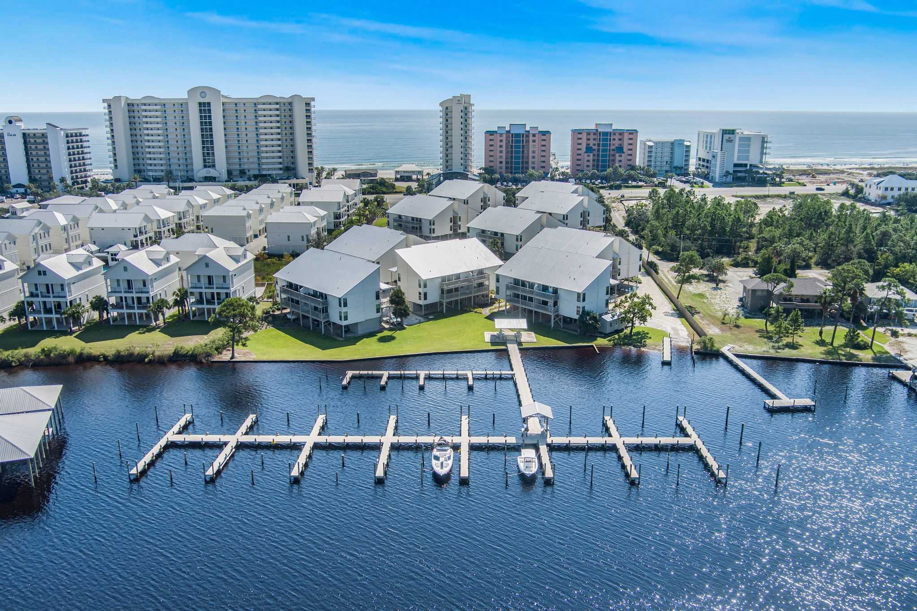 A marina with docked boats, a water body, and surrounding residential buildings.