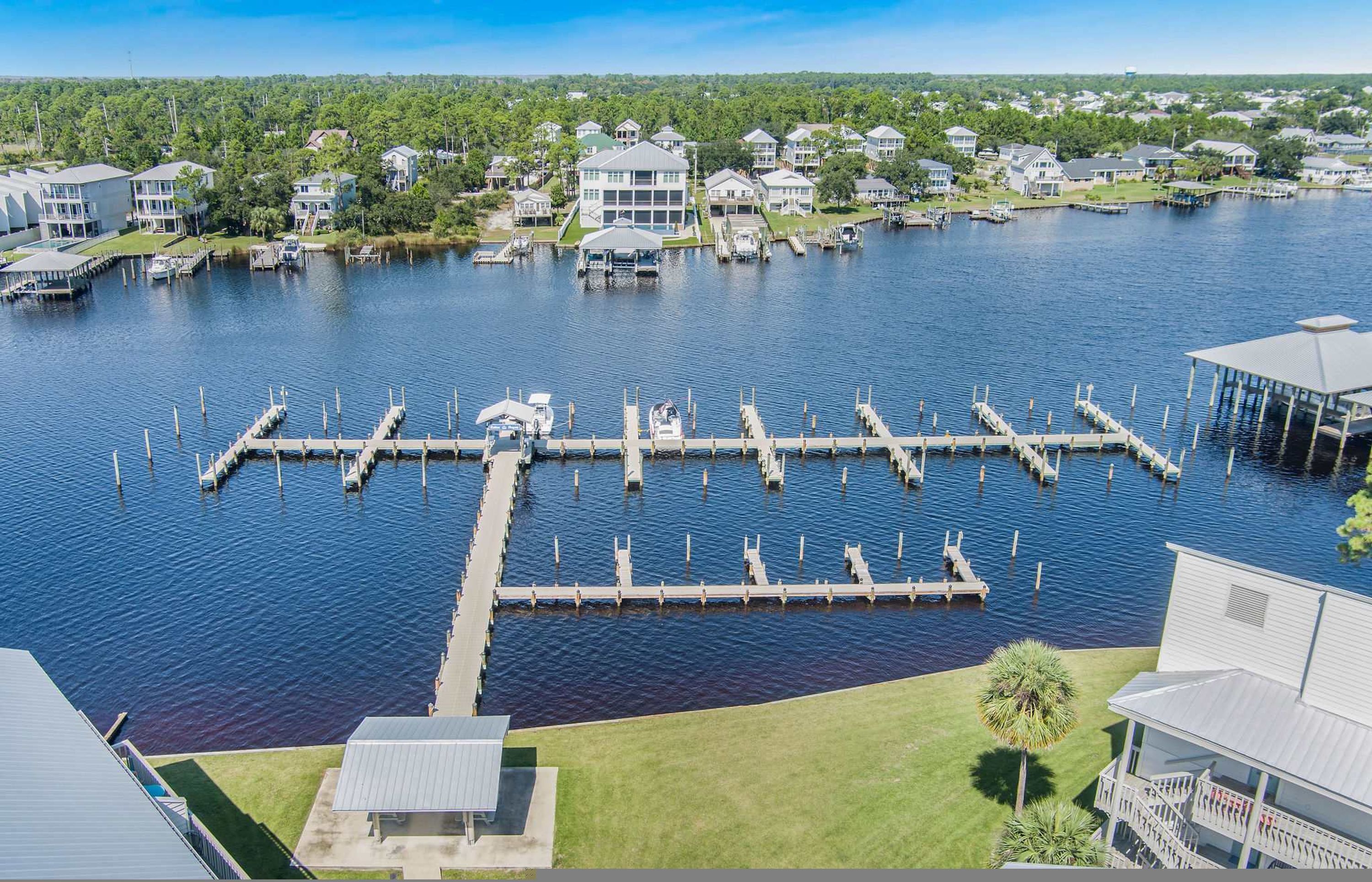 Un puerto deportivo con muelles y barcos, rodeado de casas residenciales.